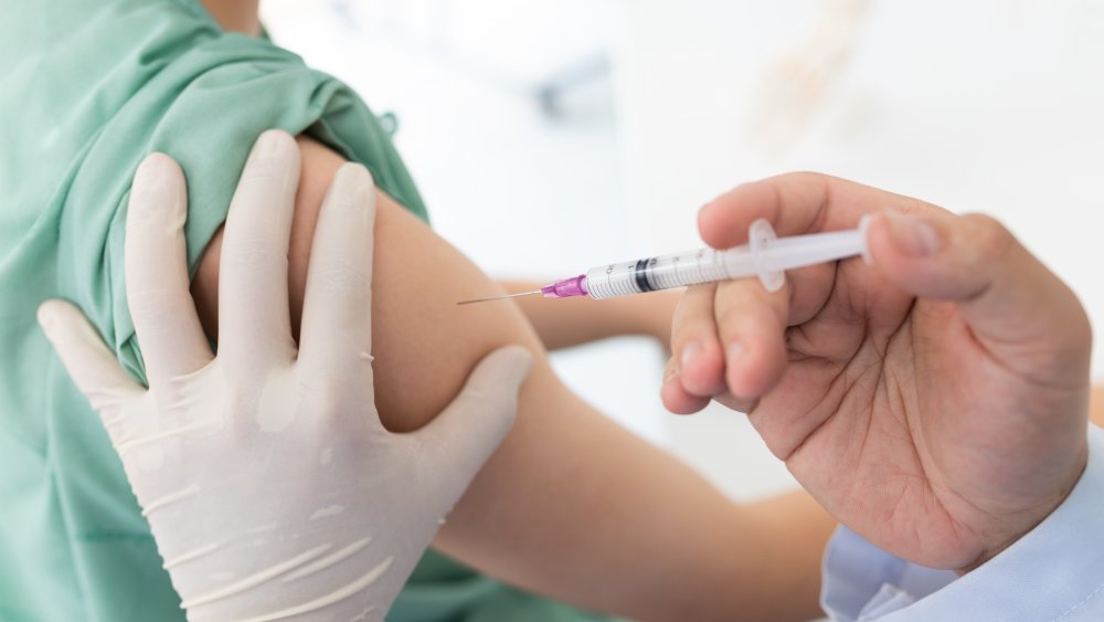 Stock photo of a person administering a vaccine in someone's arm