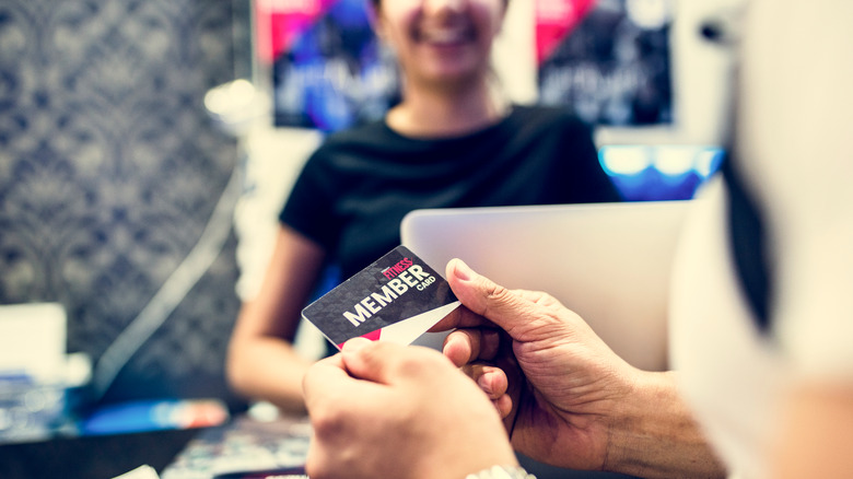 man holding gym membership card