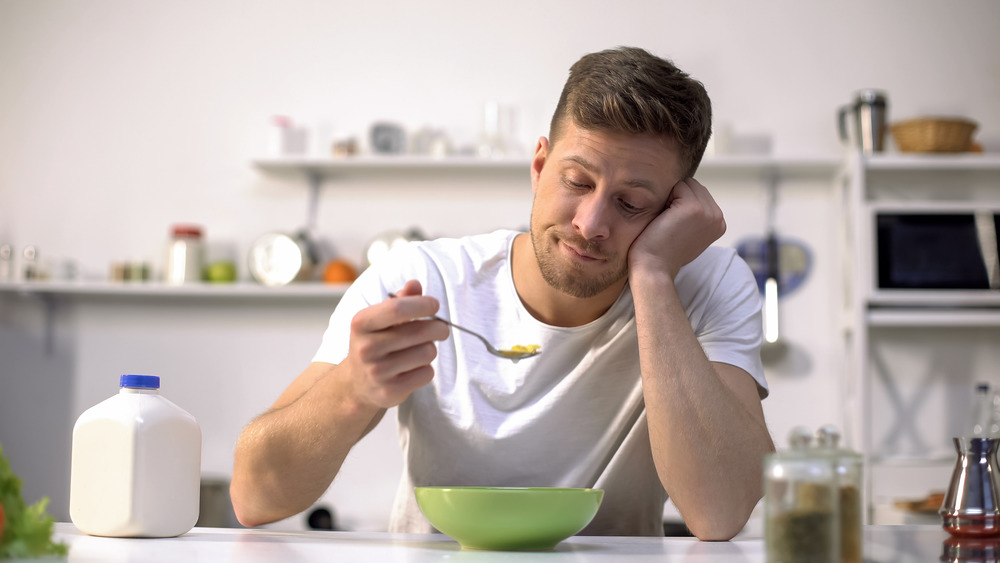 Man eating low-calorie food and looking bored