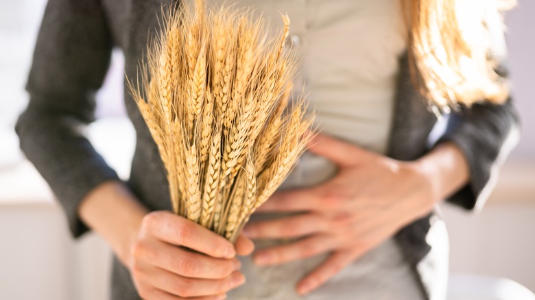 woman with gut pain holding wheat