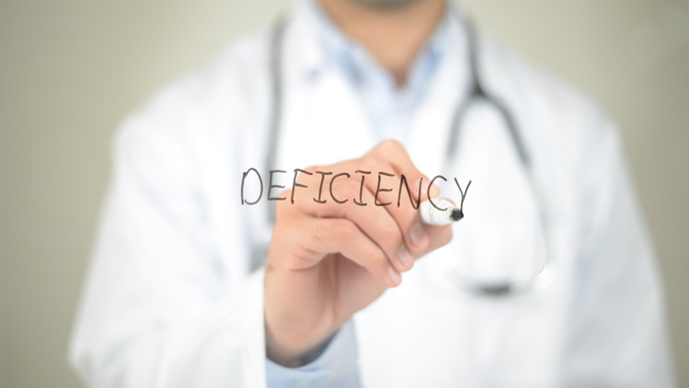 Doctor writing "deficiency"