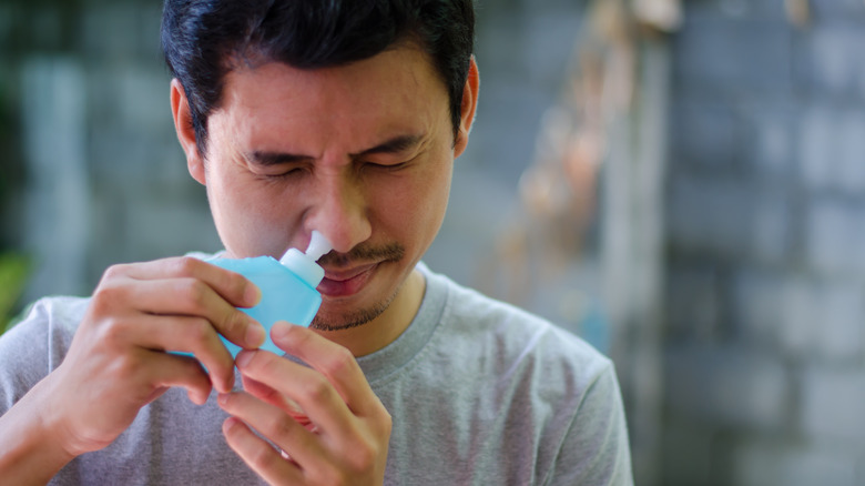 man using squeeze nasal cleanser