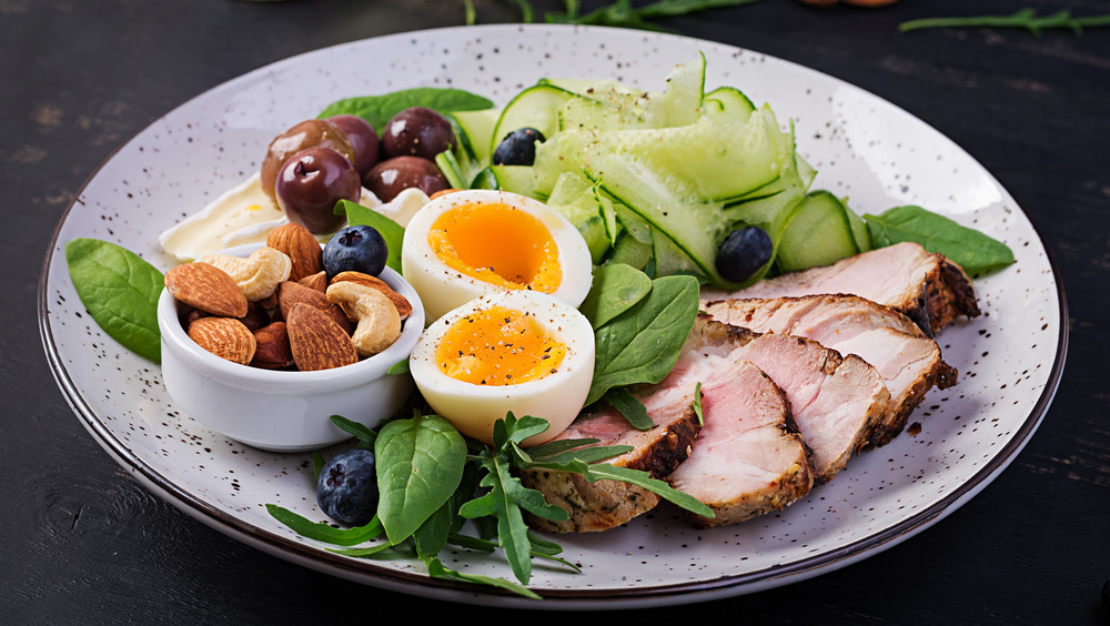 Primal meal of salad with meat, nuts, and egg