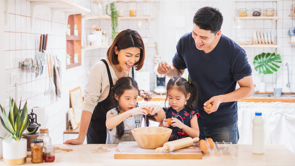 A family cooking together in the kitchen, happily