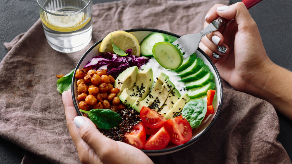 Woman with a colorful salad on her lap