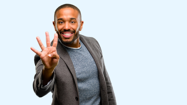 African American man raising four fingers