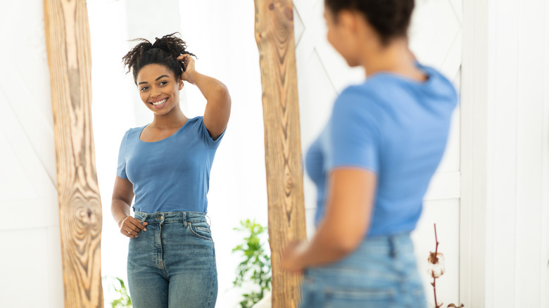 woman looking at body in mirror