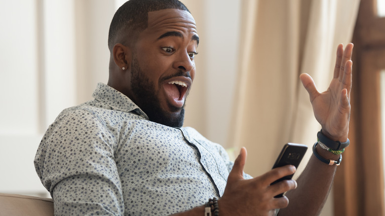 man excited looking at phone