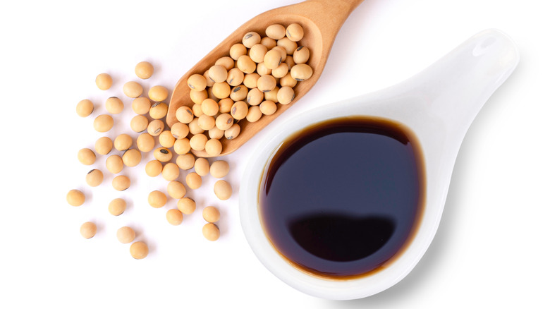 Spoon with soybeans beside soy sauce ladle