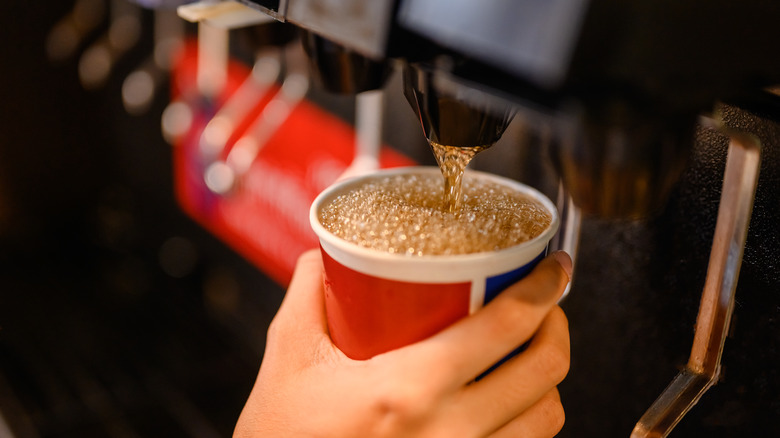 Someone gets soda from a machine