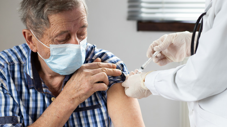elderly man receives flu shot
