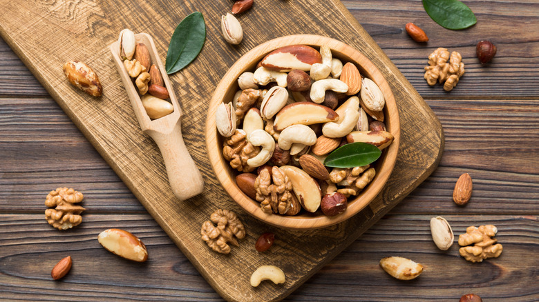 wide variety of nuts in a wooden bowl on a wood table