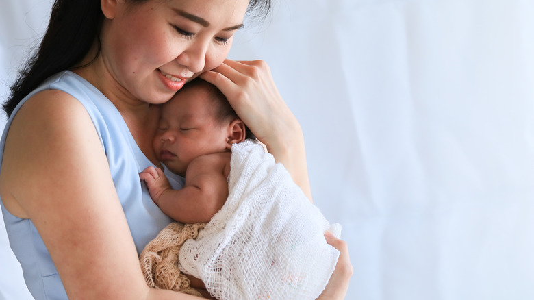 Mom holding sleeping baby