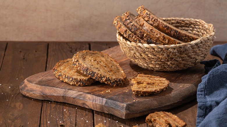 Basket of whole wheat bread on cutting board