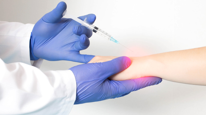 Rheumatologist injecting patient