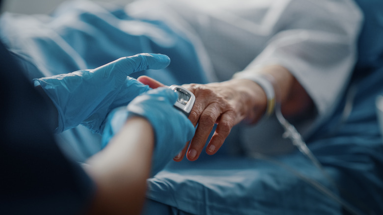 Doctor administers pulse oximeter to patient