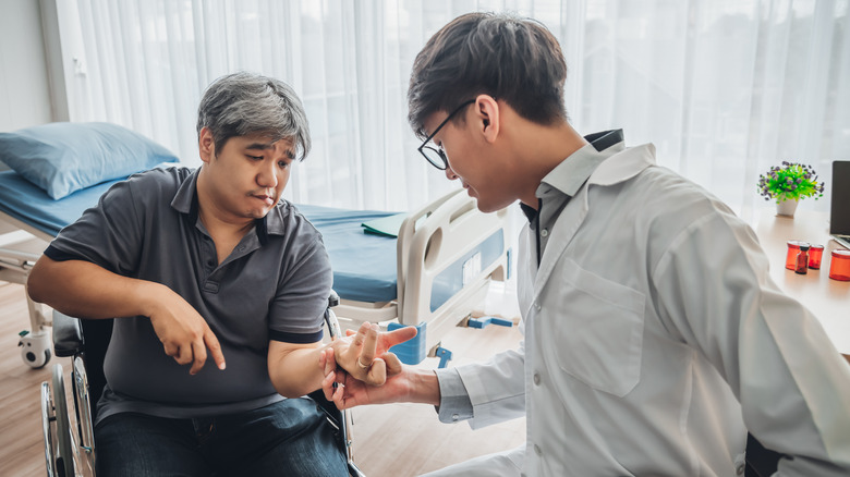 Patient with hemiplegia works with doctor