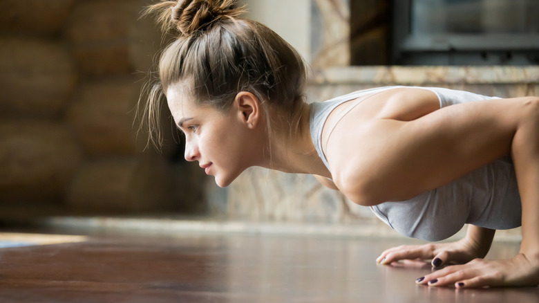 A woman does a pushup at home