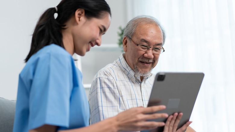 Female doctor showing a good report to patient on tablet