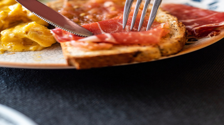 woman's hands cutting breakfast food