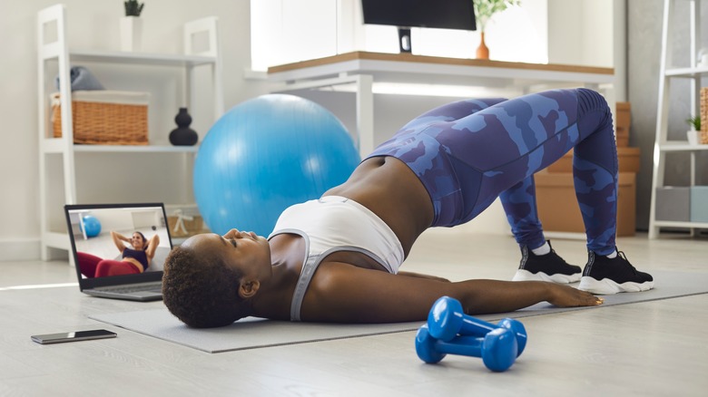 woman doing bridge pose on the floor