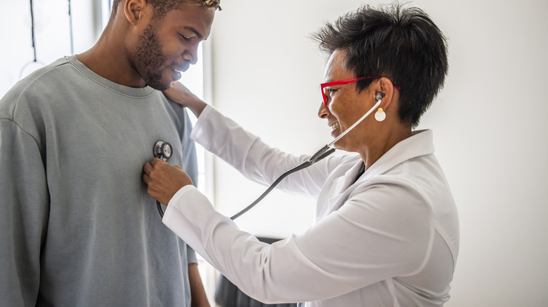 smiling doctor checking male patient