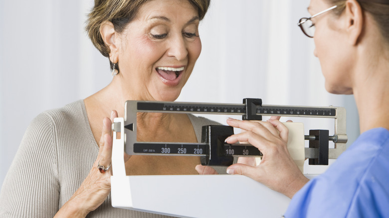 older woman happy at scale weight result