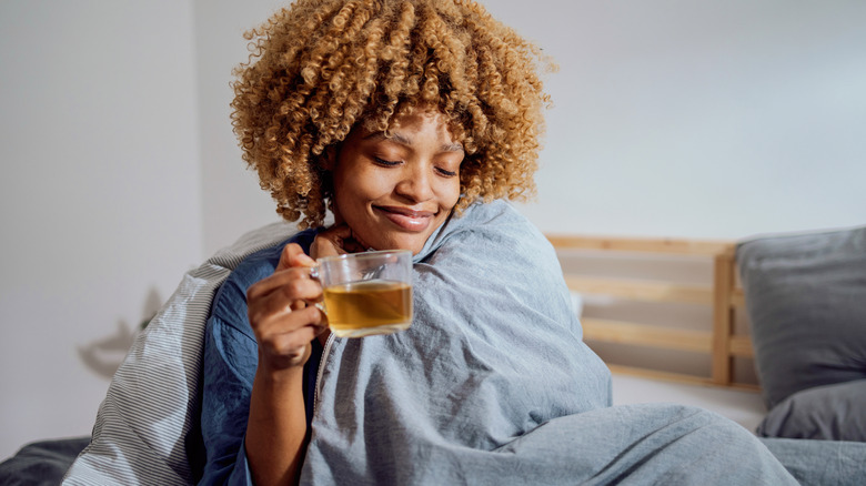 woman in bed drinking tea