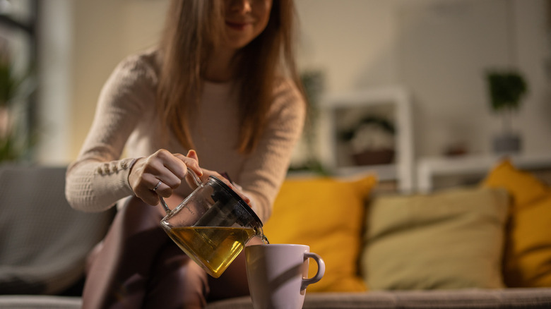 woman pouring tea into cup