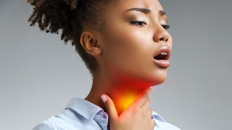 Woman touching inflamed throat