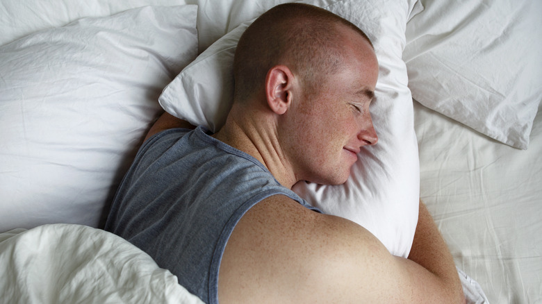 Man sleeping soundly hugging pillow