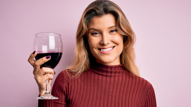 Smiling woman holding red wine