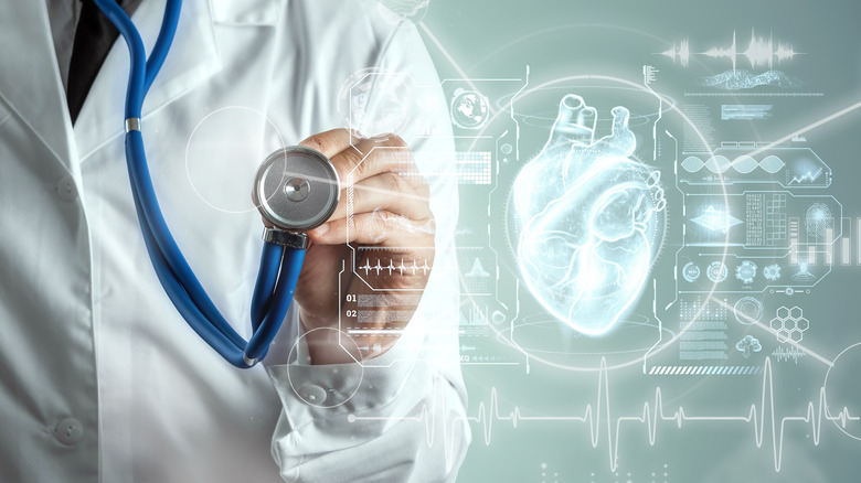 doctor with stethoscope behind graphic of heart