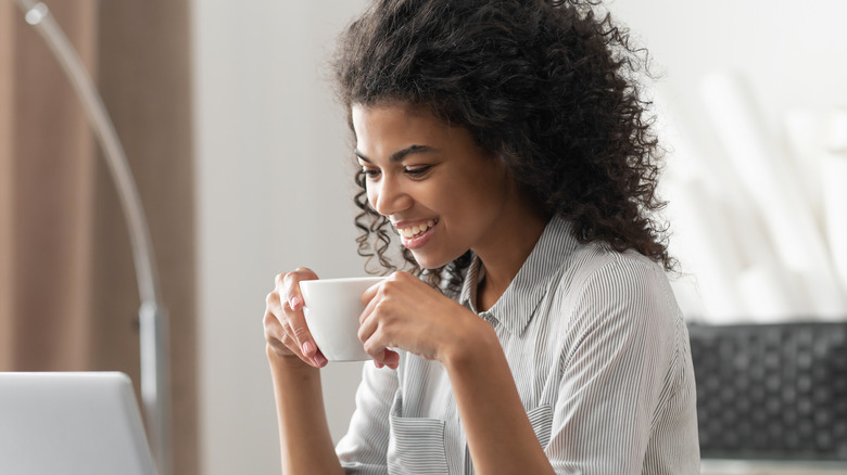 smiling young woman holding mug