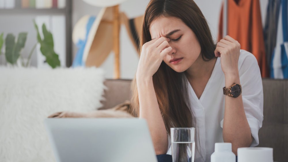 woman with a headache, one of the effects your breakup can have on your body