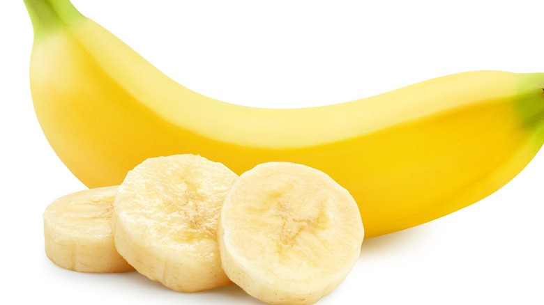 banana slices next to unpeeled banana