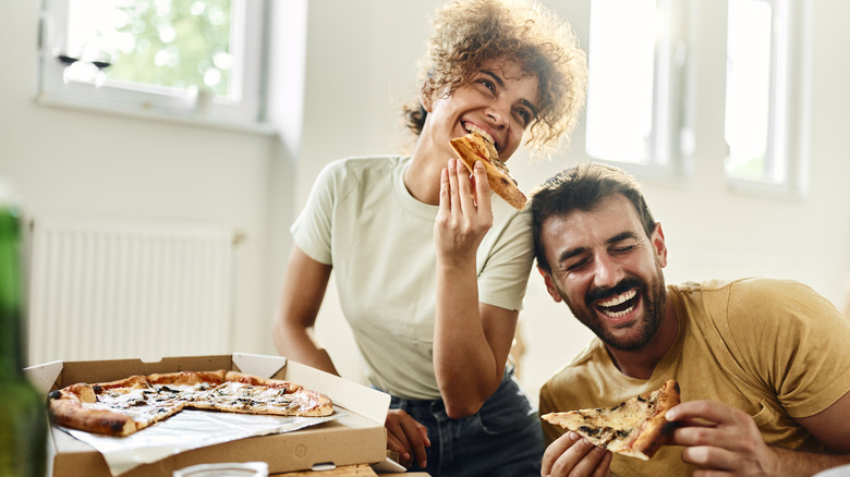 woman and man eating pizza