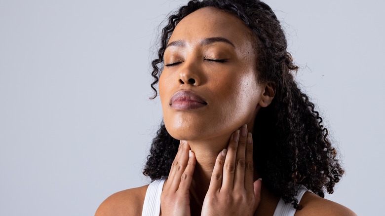 young woman touching her thyroid