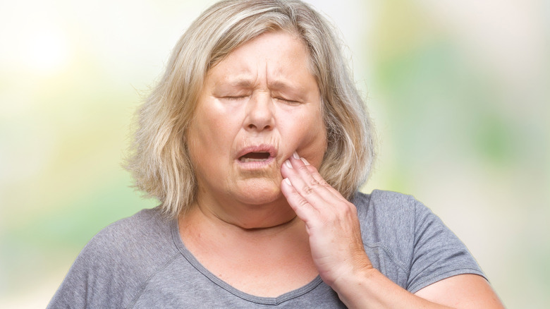 Obese woman having tooth pain 