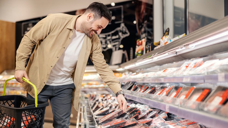 Smiling man shopping for meat