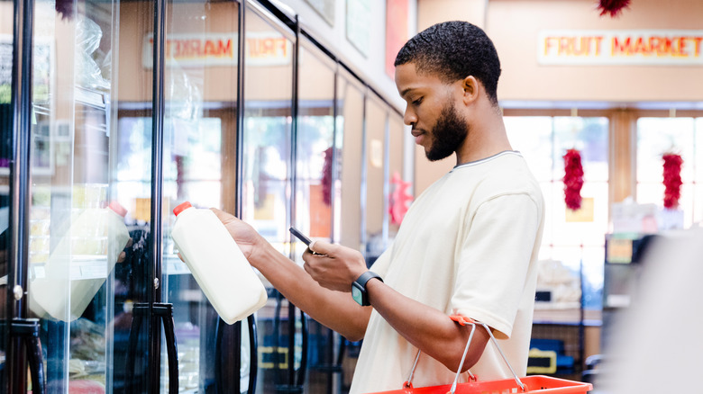 Man shopping for jug of milk