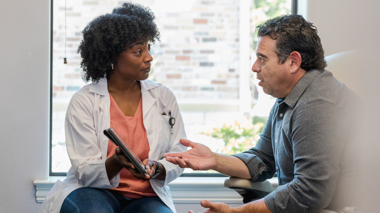 Patient explaining condition to doctor