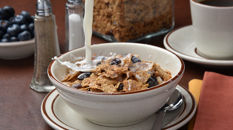 milk pouring over a bowl of Raisin Bran