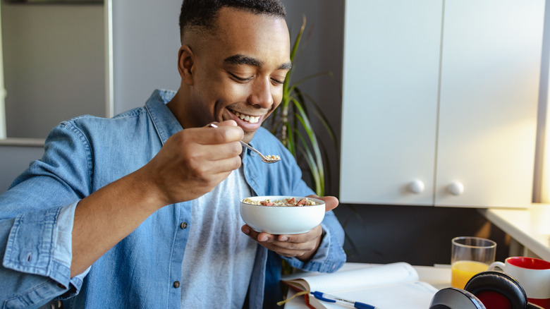 man eating cereal at his desk