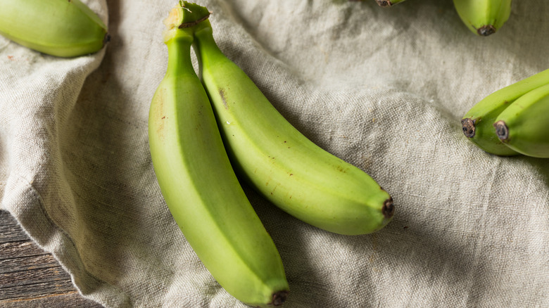 bunch of green bananas on a linen towel