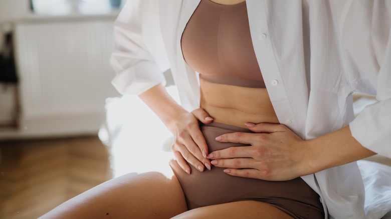 woman holding abdomen in pain