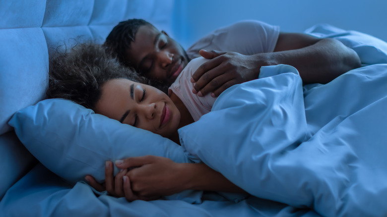 Un homme et une femme au lit qui dorment