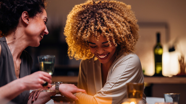 two women laughing at dinner