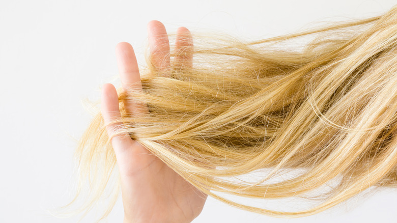 person running fingers through blond hair