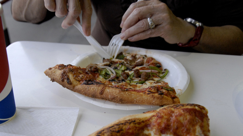 customer eating Costco pizza slice